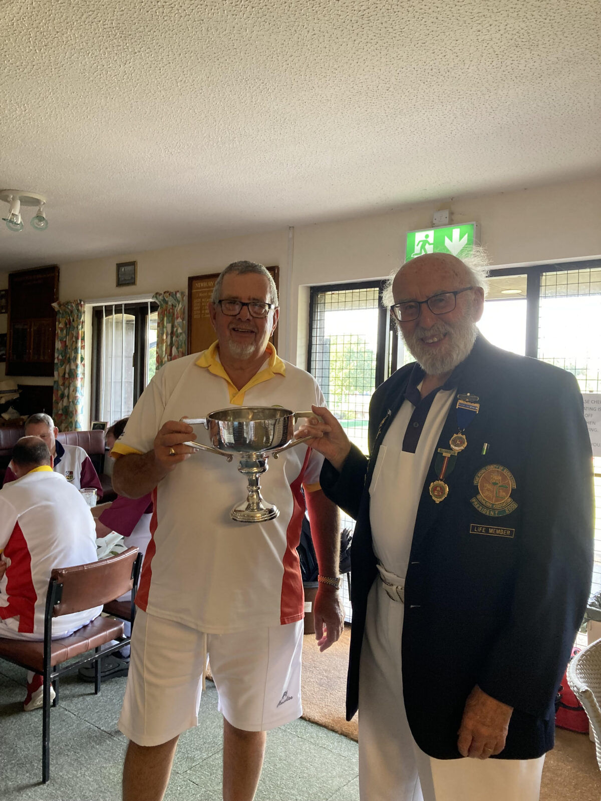 Hungerford Bowls Club President Alan Bartter receives the Godwin Cup from Newbury Bowls Captain Mike Collins.- 24th August 2025